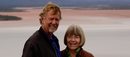 a smiling man standing in front of a body of water