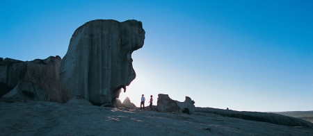 a person standing in front of a large rock