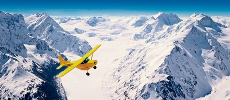 a man flying through the air on a snow covered mountain