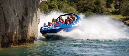 a man riding on the back of a boat in the water