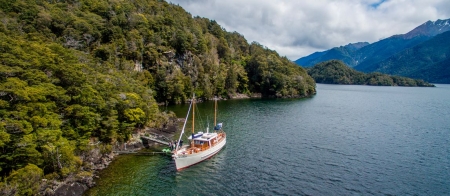 a small boat in a body of water with a mountain in the background