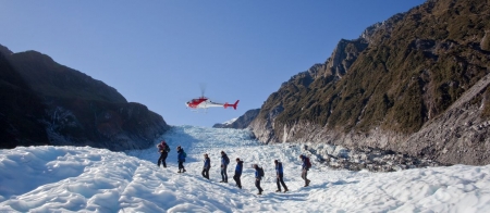 a group of people walking across a snow covered mountain