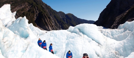 a couple of people riding on top of a snow covered mountain