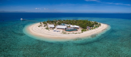 a boat sitting on top of a sandy beach next to the ocean