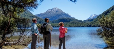 a group of people standing next to a body of water