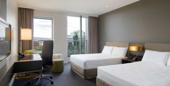 a bedroom with a bed and desk in a hotel room