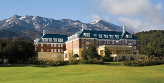 a large building with a mountain in the background