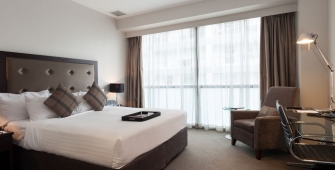 a bedroom with a bed and desk in a hotel room