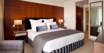 a bedroom with a bed and desk in a hotel room