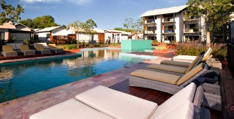 a group of lawn chairs sitting next to a pool of water