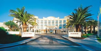 a pool next to a palm tree in front of a building