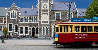 a train driving down the street in front of a building