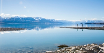 a large body of water with a mountain in the background