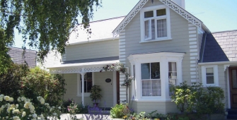 a close up of a flower garden in front of a house