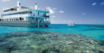 a blue and white boat sitting next to a body of water