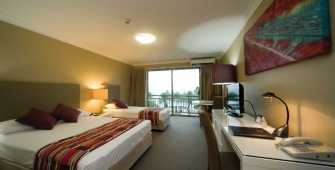 a bedroom with a bed and desk in a hotel room