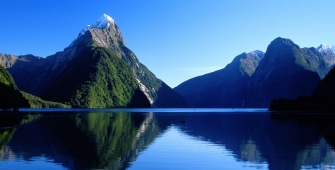 a body of water with Milford Sound in the background