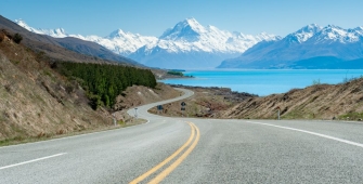 an empty road with a mountain in the background