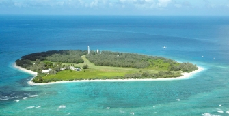an island in the middle of a body of water with Lady Elliot Island in the background