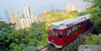 a red and white train traveling through a city
