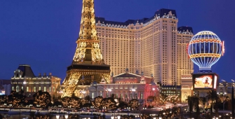 a group of people in front of a tall building with Paris Las Vegas in the background