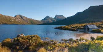 a body of water with Cradle Mountain in the background