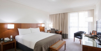 a bedroom with a bed and desk in a hotel room