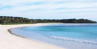 a sandy beach next to a body of water