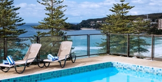 an empty park bench next to a pool of water