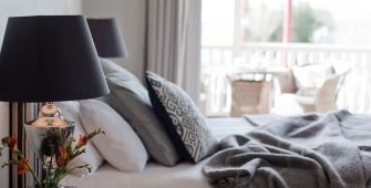 a vase of flowers sitting on a bed