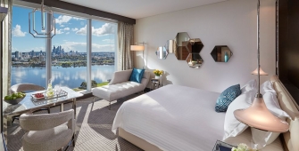 a hotel room with a bed and a chair in front of a window