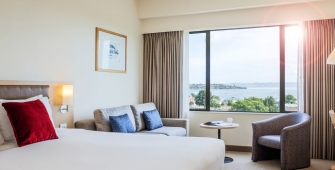 a hotel room with a bed and looking at the camera