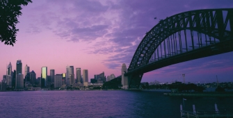 a bridge over a body of water with a city in the background