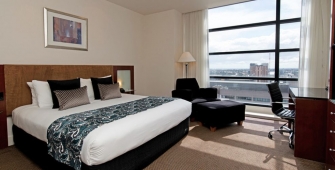 a bedroom with a bed and desk in a hotel room