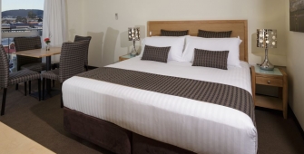 a bedroom with a bed and desk in a hotel room