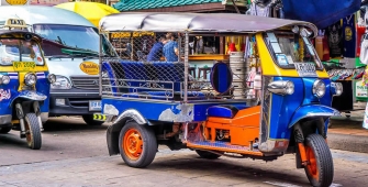 a yellow and blue truck driving down a street