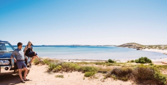 a man standing next to a body of water