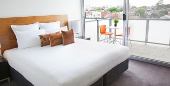 a bedroom with a bed and desk in a hotel room