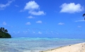 a sandy beach next to a body of water