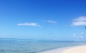 a sandy beach next to a body of water