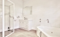 a white sink sitting next to a shower