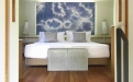a bedroom with a bed and a mirror in a room