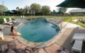 a group of lawn chairs sitting next to a pool of water