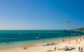 a group of people on a sandy beach next to the ocean