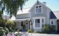 a close up of a flower garden in front of a house