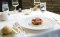 a close up of a plate of food and glasses of wine