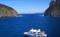 a small boat in a body of water with a mountain in the background