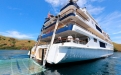 a blue and white boat sitting next to a body of water