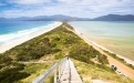 a close up of a hillside next to a body of water with Bruny Island in the background