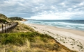 a sandy beach next to a body of water